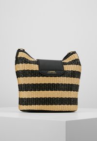 Vävd handväska med växlande svarta och naturligt beige ränder, med en svart läderklaff och guldlogotyp på framsidan.