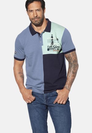 Polohemd mit blockfarbigem Design in Marineblau, Hellblau und Mint, mit einem Leuchtturm-Motiv und kurzen Ärmeln. Aus Baumwollmaterial.