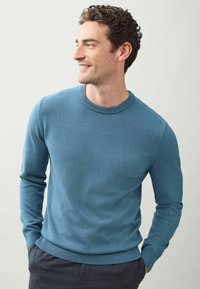 Sininen neulepaita pyöreällä kaula-aukolla, Slim fit -malli, ribbaus hihansuissa ja helmassa. Kankaan tekstuuri; sileä ulkonäkö ilman kuvioita.