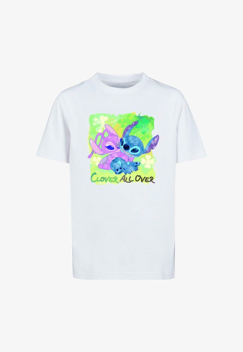 Camiseta blanca de algodón con un estampado colorido de dos personajes sobre un fondo verde con patrones de trébol. El texto dice "CLOVER ALL OVER."