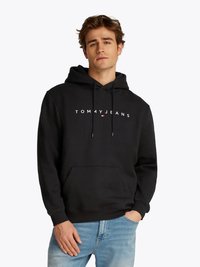 Svart hettegenser laget av bomull, med lommer foran og snøring i hetten. "TOMMY JEANS" logo trykt over brystet i hvitt.