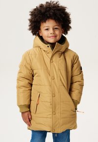 Veste rembourrée beige avec une capuche, présentant une doublure verte, des poignets côtelés, des boutons-pression à l'avant et des poches latérales avec des accents orange.