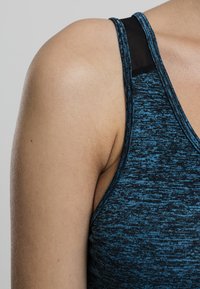 Top atletico smanicato blu e nero con un design aderente, caratterizzato da un pannello in rete sulla spalla per una maggiore traspirabilità.