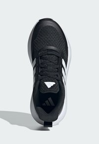 Scarpa sportiva nera con tomaia in rete, strisce bianche e suola arrotondata. Presenta un collo imbottito e un passante sul tallone.