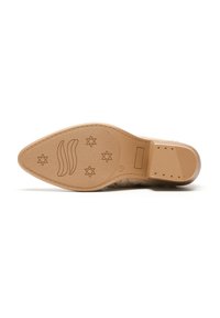 Suela de zapato con material de goma marrón claro, que presenta una superficie lisa y diseños grabados que incluyen un patrón de estrellas y elementos de logotipo.
