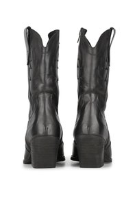 Botas de piel negras hasta el tobillo con punta afilada, cierre de cremallera, tacones altos apilados y costuras decorativas en los laterales.