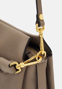 Hellgraue Lederhandtasche mit strukturierter Form, ausgestattet mit einem goldfarbenen Metallkarabinerhaken, Reißverschlussdetails und verstärkten Nähten.