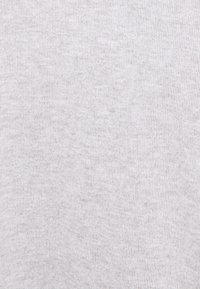 Lichtgrijze stof met een ribbelstructuur, met een zachte, gladde oppervlakte en subtiele spikkels. Effen kleur zonder opvallende patronen.