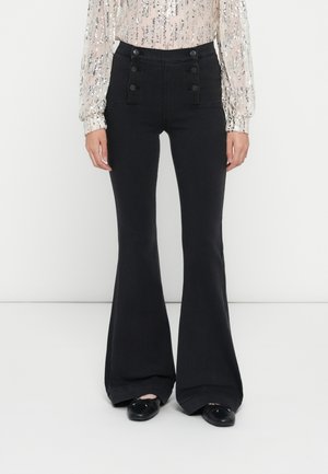 Pantaloni a vita alta neri a campana con quattro bottoni decorativi sulle tasche anteriori. Tessuto morbido con una vestibilità strutturata e orlo ampio.