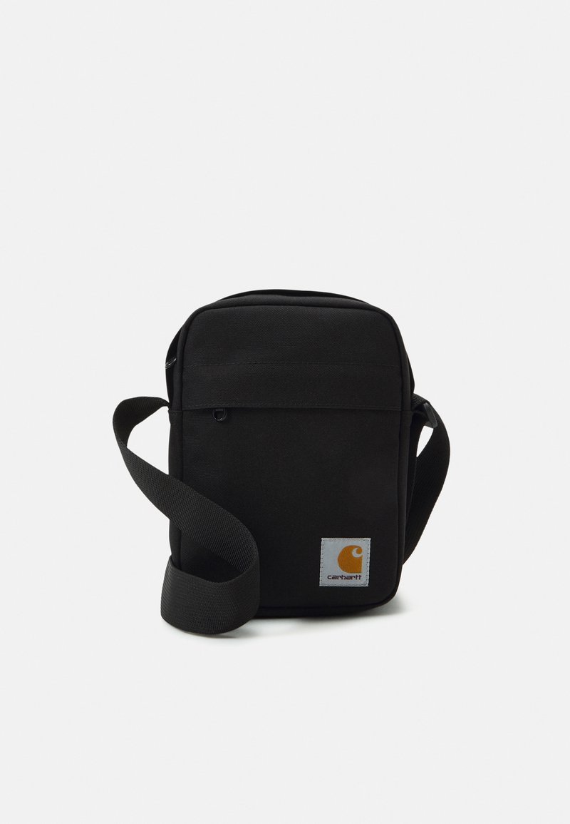 Borsa a tracolla in tessuto nero con cinturino regolabile, scomparto principale con zip, tasca frontale e vistoso patch del logo Carhartt arancione.