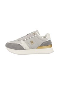 Sneakers grigio chiaro realizzati in camoscio e pelle, con una striscia bianca e un dettaglio metallico dorato sul tallone. Design semplice con lacci.