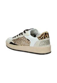 Sneaker bianca e beige con un pannello laterale glitterato oro, dettagli neri e un tallone con stampa leopardata con branding in rilievo sul retro.