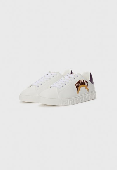 Tenisi albi din piele cu o talpă texturată albă. Au accente violete și logo-ul auriu "VERSACE" pe lateral, cu șireturi albe.