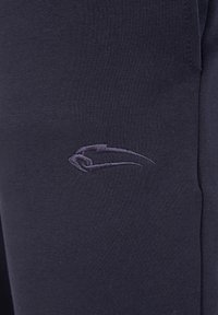 Pantalones deportivos de color marino, hechos de un material suave y elástico, con un pequeño logotipo bordado en un tono contrastante en el muslo.