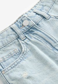 Ljusblå denimshorts med en silverknapp, framfickor och diskret slitage n�ära fållen och fickorna. Texturerad tyg.