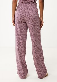 Pantalon large à motifs violets et roses avec un design en zigzag texturé. Taille élastique pour le confort, tissu lisse étalé à plat.