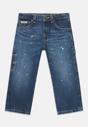 Jean en denim bleu avec des détails d'éclaboussures de peinture, poches avant, fermeture par bouton et une petite poche latérale sur la jambe gauche.