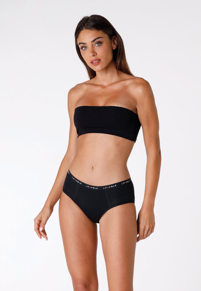 Top bandeau nero e mutande a vita alta realizzati in morbido tessuto. L'elastico in vita presenta un contrastante logo "LOVABLE" in rosso.