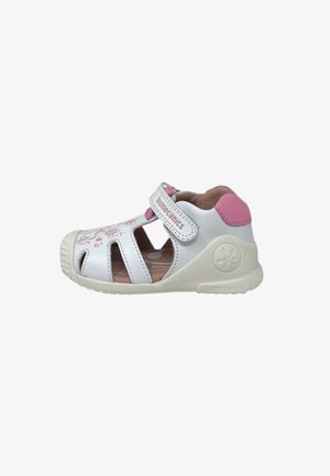 Sandalo per bambino piccolo bianco e rosa con punta chiusa, ritagli laterali, cinturino in Velcro, design floreale sulla parte anteriore e marchio "Biomecanics" sul cinturino e sulla suola.
