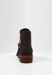 Brun mocka ankelstövel med rund tå, kraftig träklack, guldfärgade detaljer och dragkedjestängning på sidan.