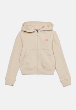 Μπεζ φούτερ με κουκούλα και φερμουάρ, με εμπρόσθιες τσέπες και μικρό ροζ λογότυπο "NB" στο αριστερό στήθος, σχεδιασμένο για καθημερινή χρήση.