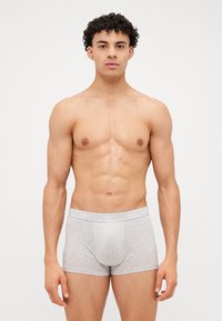 Graue Boxershorts mit einem enganliegenden Design und einem weichen, dehnbaren Stoff. Sie verfügen über einen hellgrauen Bund mit einem Logomuster auf der Vorderseite.