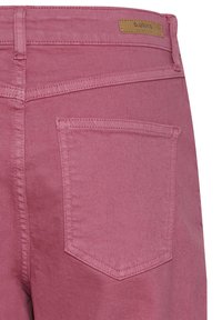 Jeans de mezclilla rosa que muestran el bolsillo trasero y una pequeña etiqueta de marca marrón en la cintura.