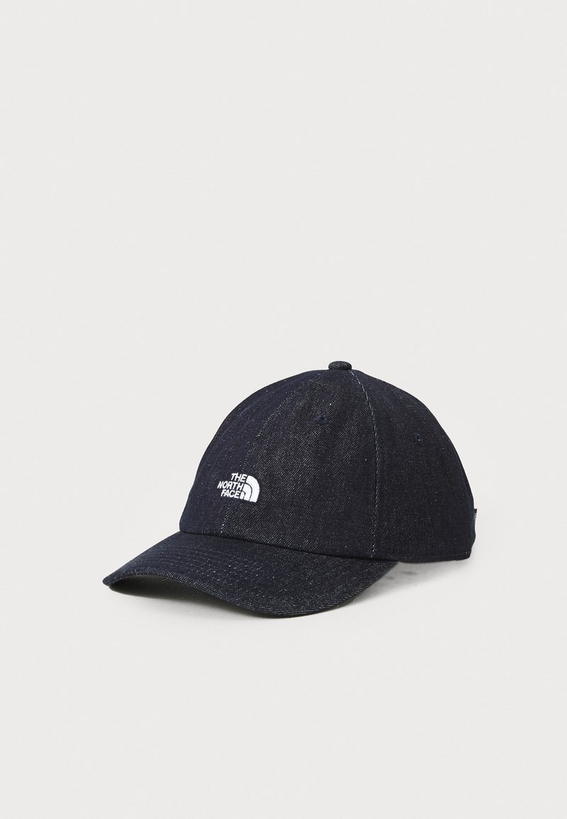 Sötét denim baseballsapka fehér logóval az elején, kerek koronával és ívelt csúccsal. Tartós anyag, hat paneles kialakítás, minimális díszítéssel.