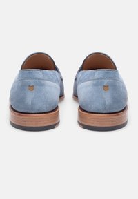 Blaue Wildleder-Schuhe mit runder Spitze, glatter Oberfläche und braunem, geschichtetem Holzsohle. Verfügt über einen kleinen sandfarbenen Akzent an der Ferse.