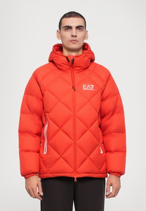 Red puffer jacket with a geometric quilted pattern, hood, two side zippered pockets, and EA7 logo on the left chest. Smooth texture.
