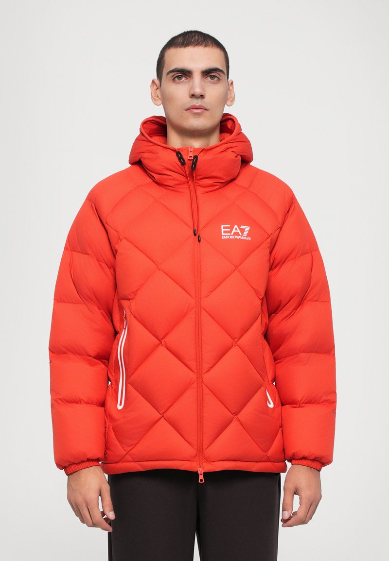 Red puffer jacket with a geometric quilted pattern, hood, two side zippered pockets, and EA7 logo on the left chest. Smooth texture.