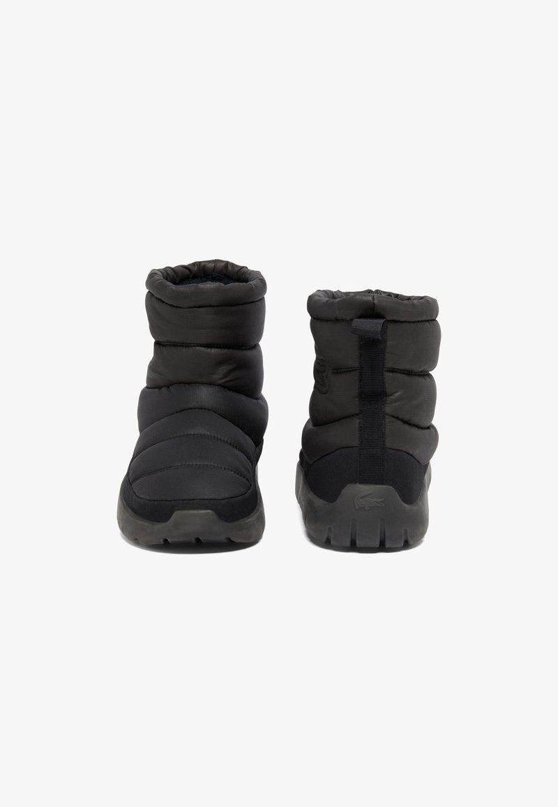 Schwarze gepolsterte Stiefeletten mit flexiblem Design, strukturiertem Stoff und Gummisohlen. Mit einer Schlaufe an der Rückseite für ein einfaches Anziehen.