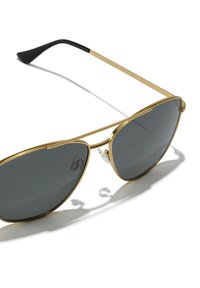 Ochelari de soare aviator aurii cu lentile gri închis, având un cadru subțire, vârfuri negre pentru brațe și tampoane de nas transparente pentru confort.