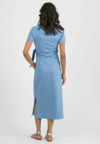 Blaues Midikleid mit kurzen Ärmeln, tailliertem Schnitt und einer Schleifen-Dekoration auf der Rückseite. Verfügt über einen seitlichen Schlitz, glattes Material und ein lässiges Design.