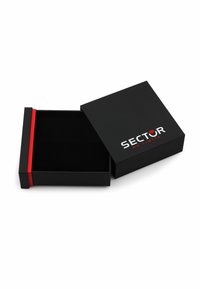 Scatola di cartone nera con una banda di accento rossa, caratterizzata da un'esterno liscio e un'apertura superiore, che mostra il logo "SECTOR NO LIMITS".