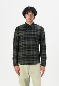 Camisa de cuadros en negro y verde oliva, de mangas largas, con frente abotonado, hecha de una tela suave con un cuello clásico y una textura sutil.