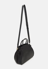 Svart läderhandväska med texturerad yta, försedd med en avtagbar axelrem och dubbla topphandtag. Rundad botten och minimal hårdvara.