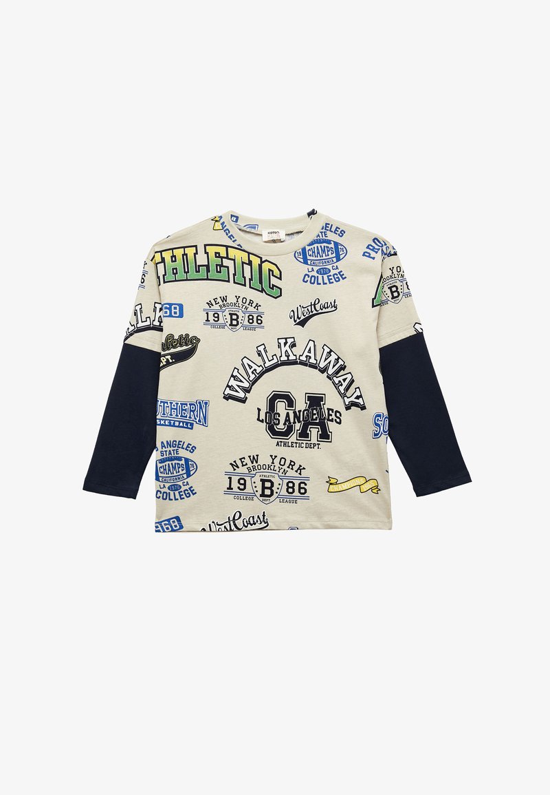 T-shirt à manches longues en crème avec des manches bleu marine, présentant divers graphismes imprimés et du texte en vert, bleu et noir. En matériau coton.