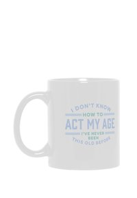 Taza de cerámica blanca con un asa grande que presenta un texto azul: "NO SÉ CÓMO ACTUAR DE MI EDAD, NUNCA HE SIDO TAN VIEJO ANTES."