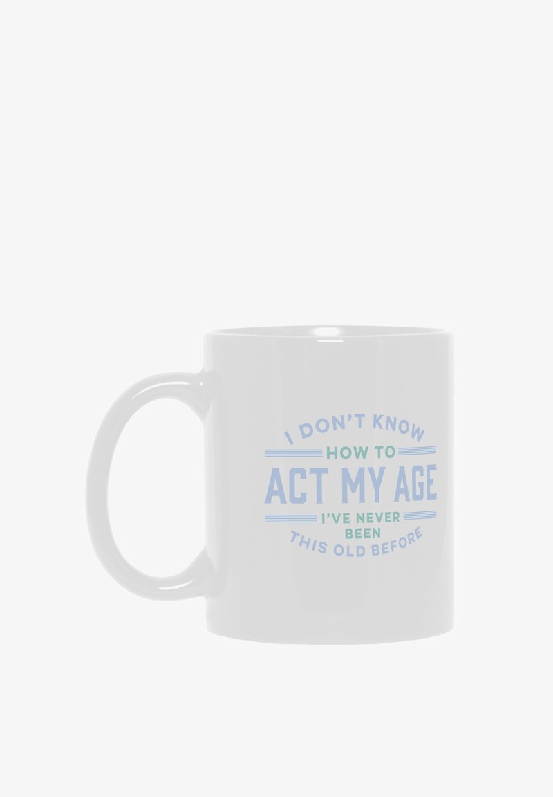 Taza de cerámica blanca con un asa grande que presenta un texto azul: "NO SÉ CÓMO ACTUAR DE MI EDAD, NUNCA HE SIDO TAN VIEJO ANTES."