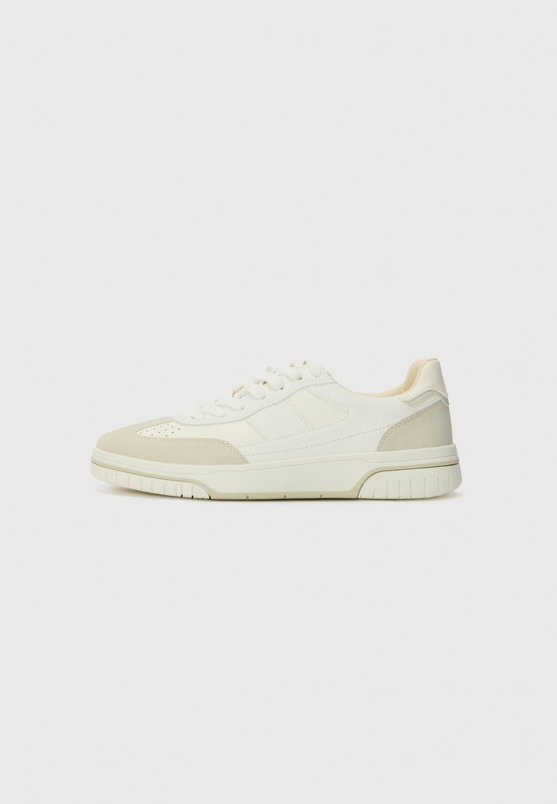 Sneakers with a white and light beige color scheme, featuring a smooth leather upper, textured suede accents, and a rubber sole.