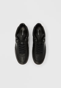 Schwarze Ledersneaker mit abgerundeter Spitze, strukturierten Einsätzen und schwarzen Schnürsenkeln. Verfügen über silberne Ösen und ein Logo auf der Innensohle. Dünne Gummisohle.