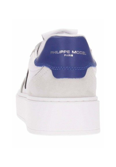 Sneaker bianco con un'accents blu sul tallone, realizzato in pelle e suede, dotato di una suola bianca spessa e logo del brand impressa sul retro.