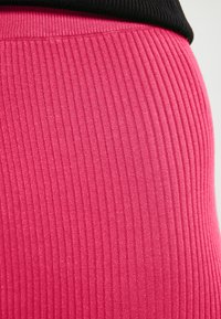 Material roz cu dungi, cu o textură lucioasă, având un design ajustat. Marginea superioară este neagră, contrastând cu rozul vibrant de dedesubt.
