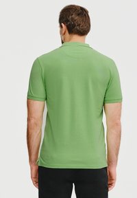 Zielona koszulka polo z gładkiego materiału, z krótkimi rękawami i klasycznym kołnierzykiem, o prostym kroju i bez widocznych wzorów.