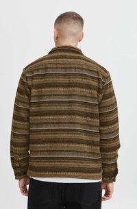 Chaqueta marrón con un patrón de rayas horizontales en varios tonos. Hecha de una tela texturizada, cuenta con un cuello y puños abotonados.