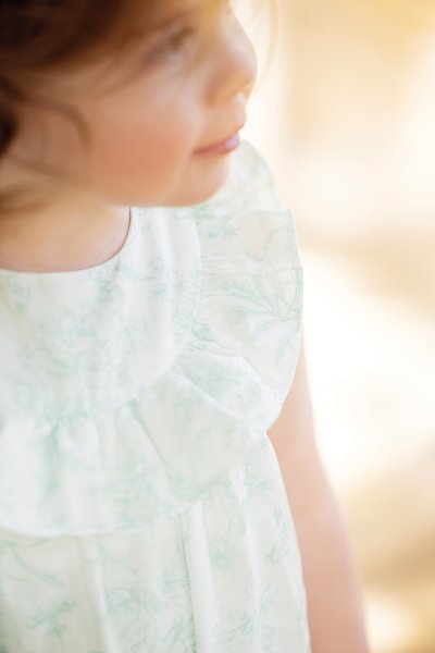 Light green floral-patterned dress with a ruffled neckline and short sleeves. Made of soft fabric, featuring a loose, comfortable fit.