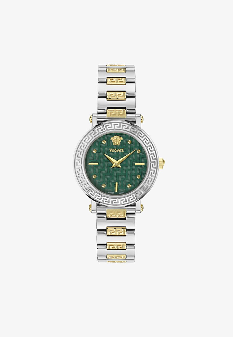Kerek Versace óra zöld mintázatú számlappal, ezüst és arany színű fém szíjjal, valamint görög kulcs mintázattal a kereten. Arany mutatók és jelzések.
