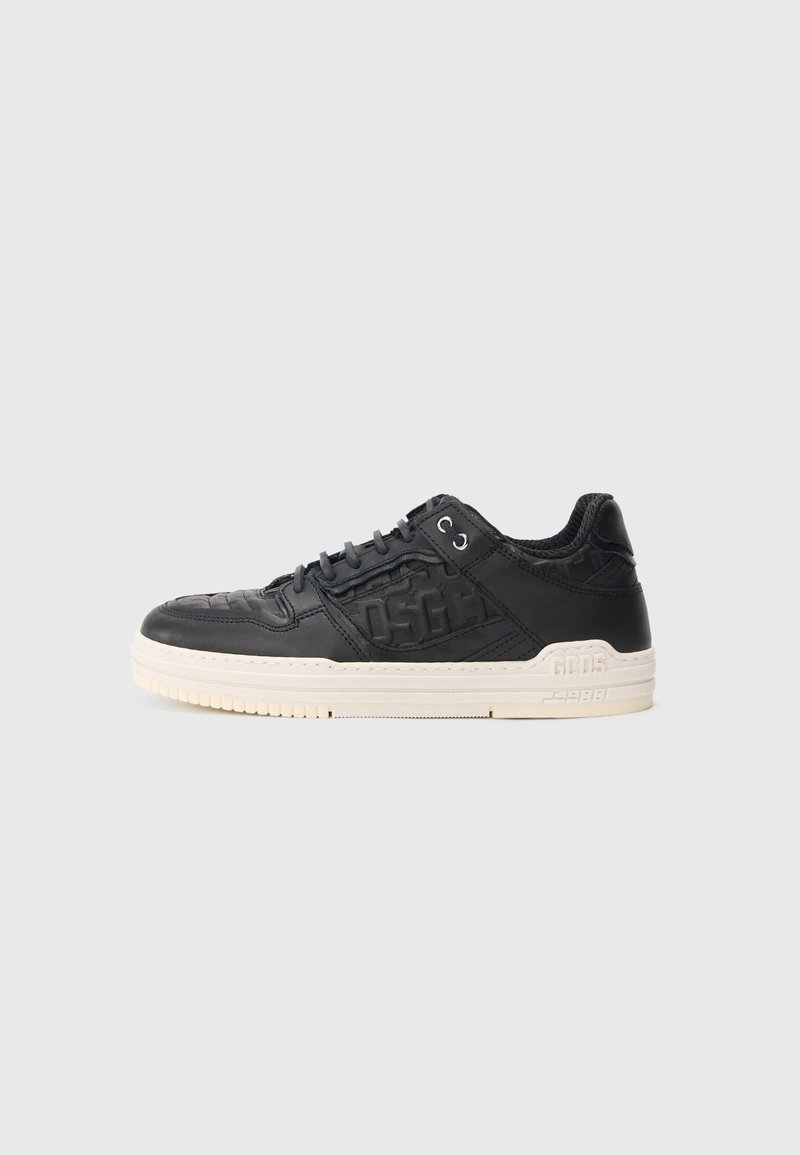 Czarne skórzane sneakersy z teksturowanym wierzchem, białą gumową podeszwą i wyraźnym logo po boku. Okrągły czubek i sznurowana konstrukcja.
