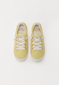 Baskets en toile jaunes avec des lacets blancs, bout rond et semelles intérieures à motifs floraux. Semelles en caoutchouc et couture contrastante.